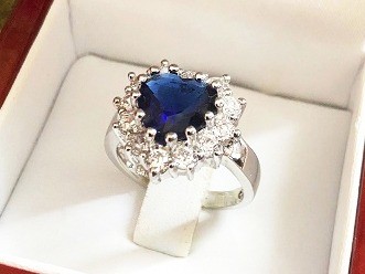 Gouden solitair ring met ronde blauwe saffier en zirkonia's